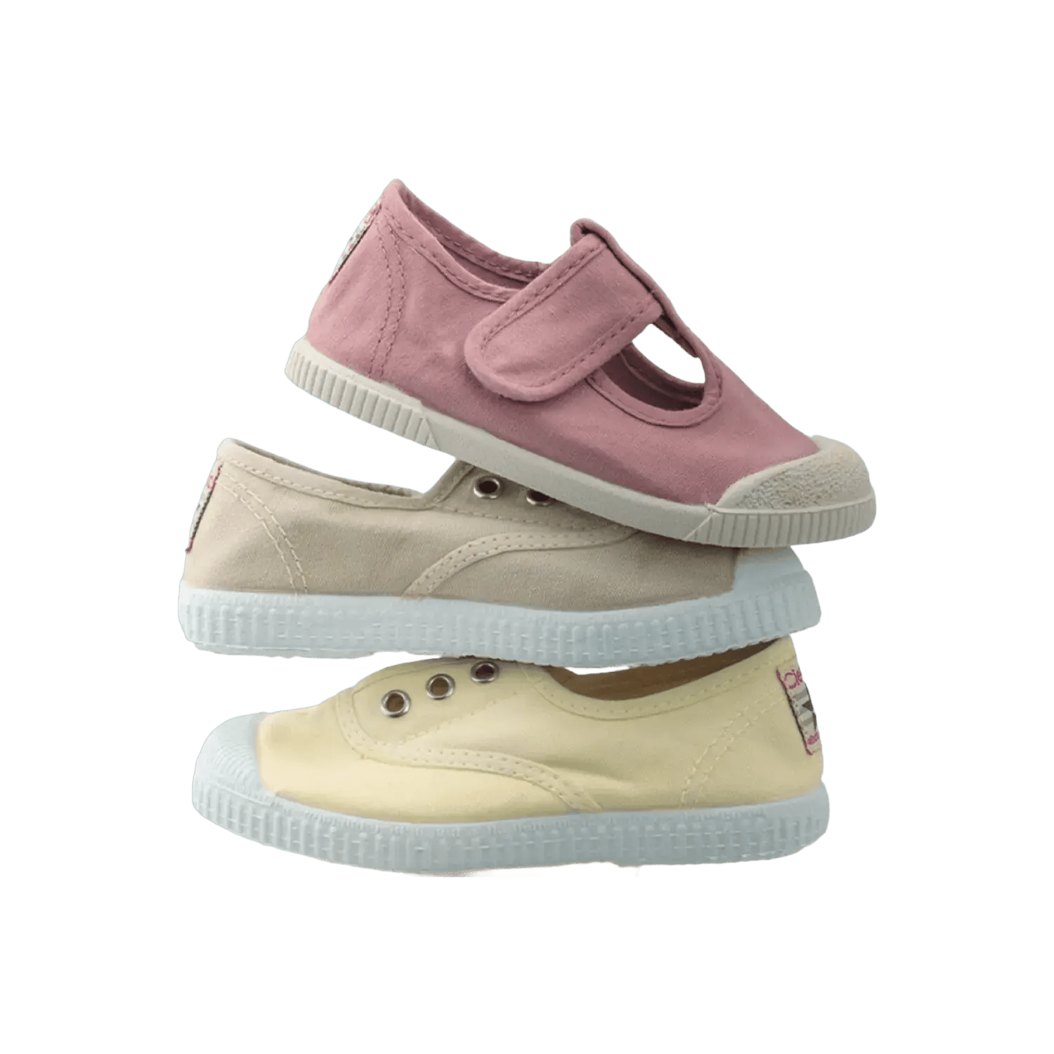 Cienta multi-colored stack of canvas sneakers for kids in pastel pink, beige, and yellow, showcasing a variety of summer styles. Official B2B collection preview via Moda Vostra agency.